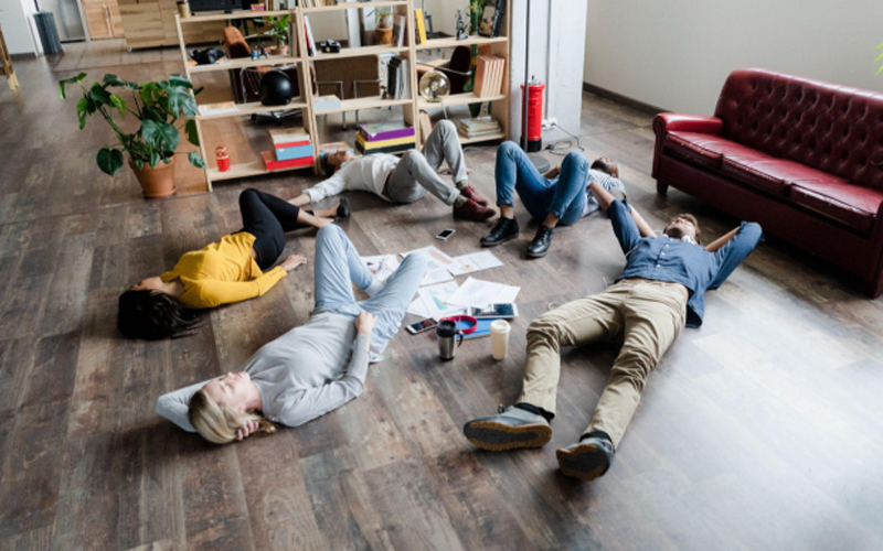 Business team lying on the floor surrounded by documents in loft office