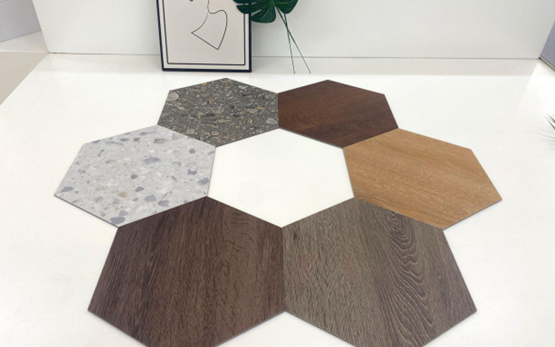 Hexagonal tiles samples in various textures and colors displayed on a white surface.