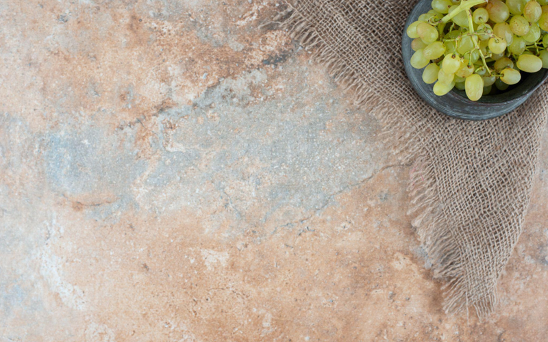 Fresh green grapes on warm-toned stone surface
