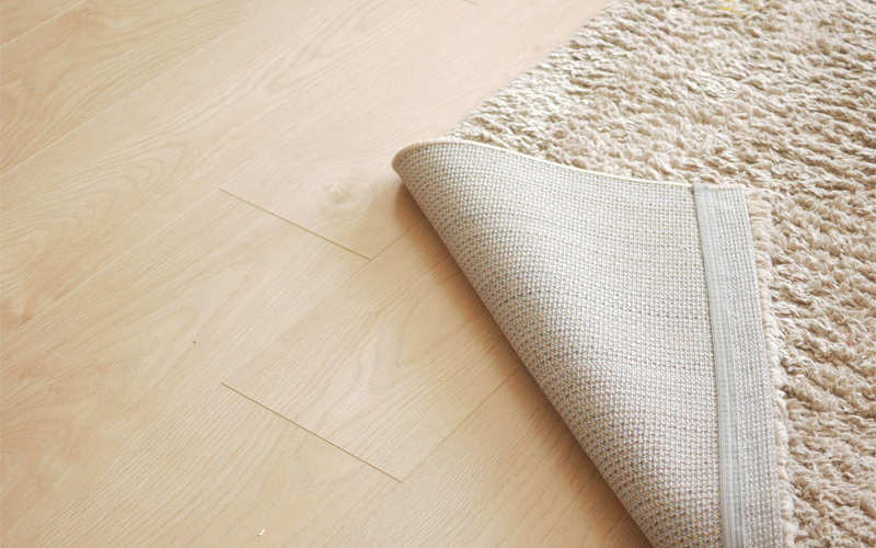 Lifted corner of a new carpet on the vinyl flooring